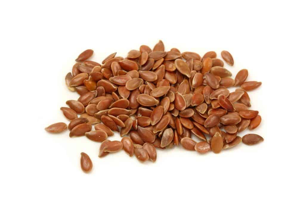 Brown flaxseeds on white background. Flaxseeds for Hair Growth Article 